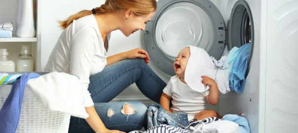 A imagem mostra uma mulher lavando as roupas e cobertas do seu bebê.